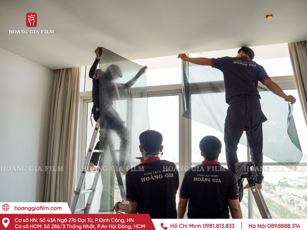 Kỹ thuật viên vệ sinh bề mặt kính trước khi thi công phim cách nhiệt.